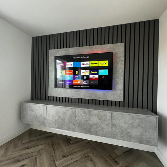 Smart TV mounted on a decorative wall with a concrete cabinet below in a modern living room.