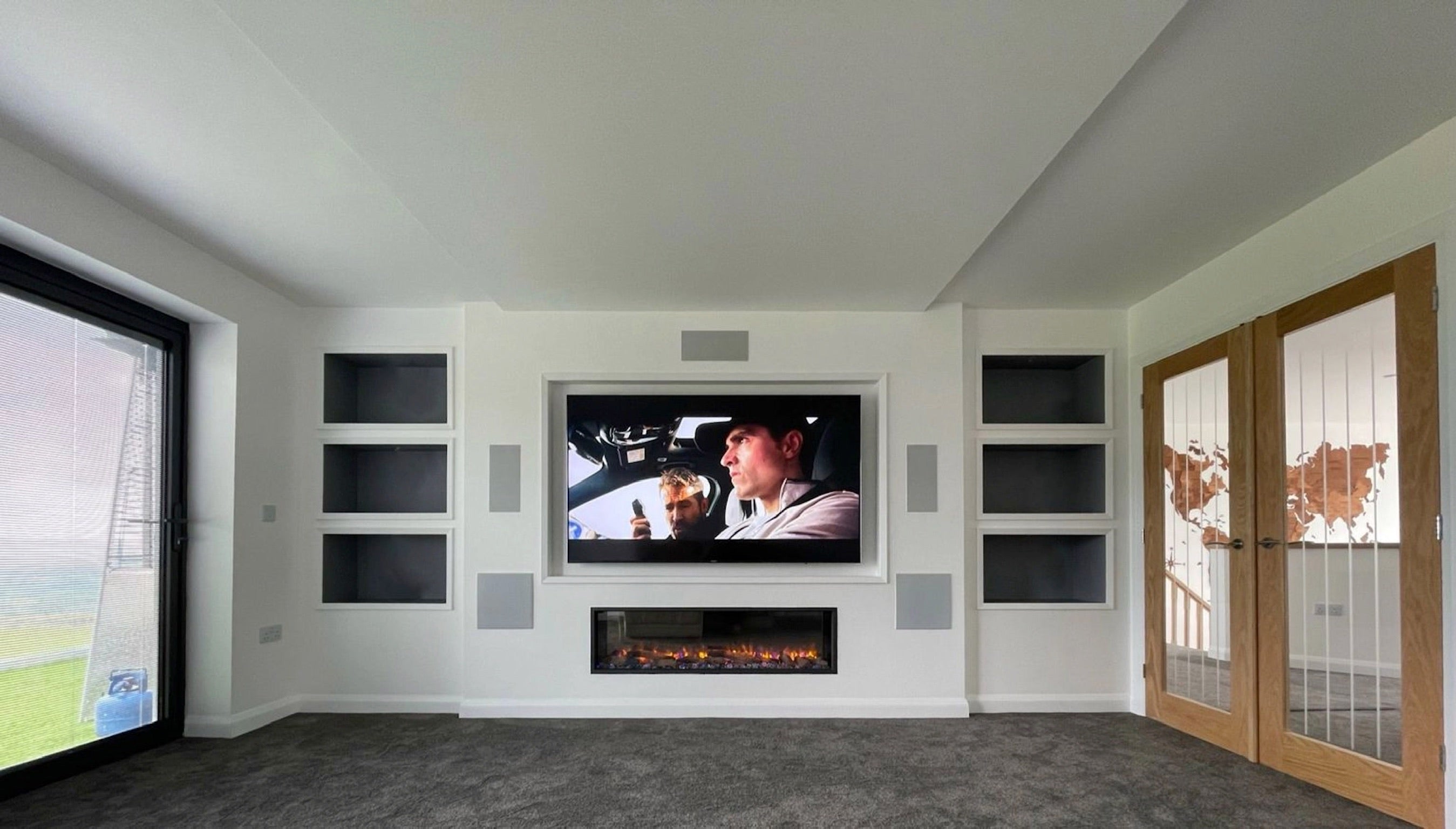 Media wall installation with electric media wall recessed fire and dolby atmos home cinema system at Emotive AV Cornwall